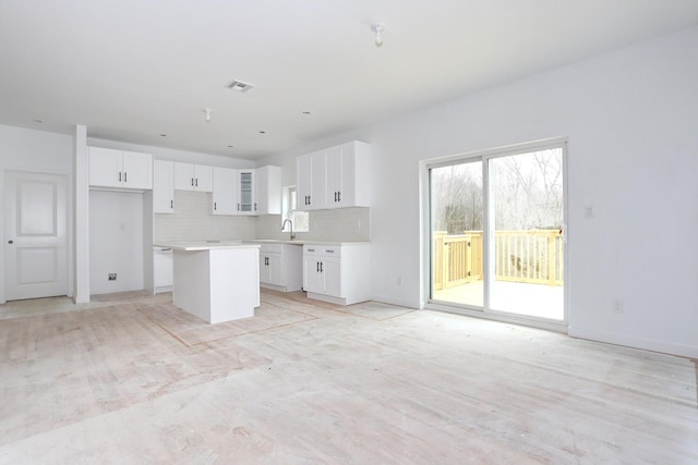 334NOhioville Rd, New Paltz, NY 12561 - kitchen featuring white cabinets, light countertops, a sink, a center island, and decorative backsplash