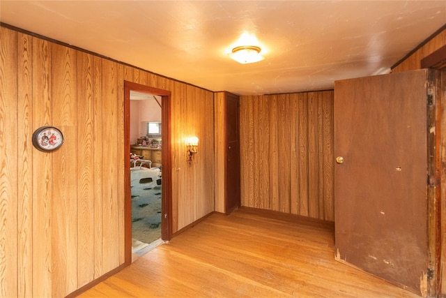 corridor featuring wooden walls and light wood-type flooring