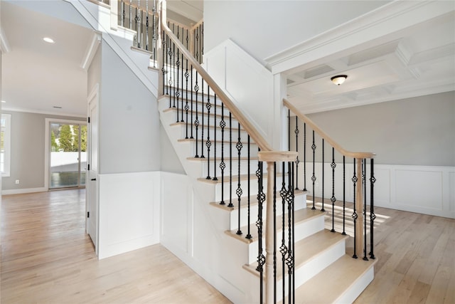 stairs with recessed lighting, a decorative wall, ornamental molding, wainscoting, and wood finished floors