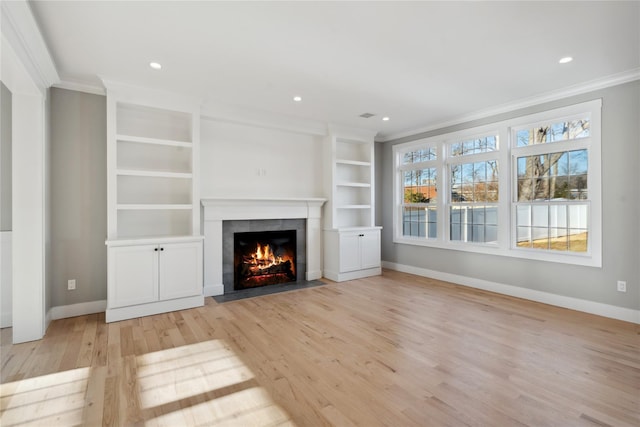 unfurnished living room with a fireplace, light wood finished floors, ornamental molding, and baseboards