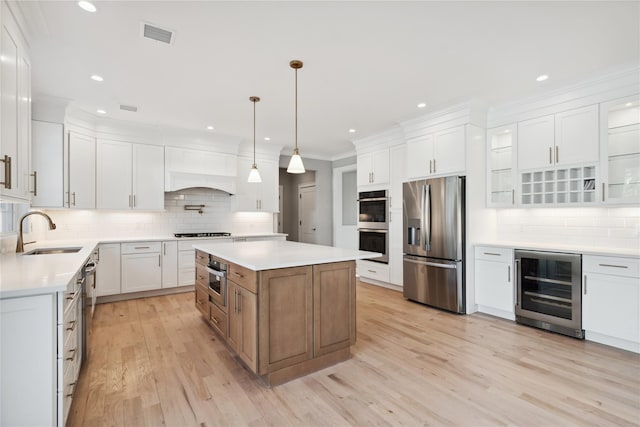 kitchen with wine cooler, appliances with stainless steel finishes, decorative backsplash, and a sink