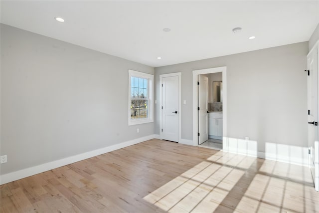 spare room featuring recessed lighting, light wood-style flooring, and baseboards