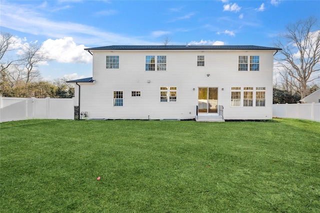 rear view of property with a yard and a fenced backyard