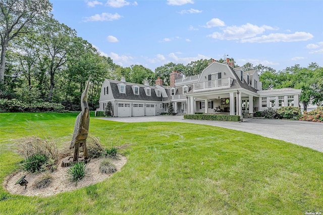 279 Little Neck Rd, Centerport, NY 11721 - view of front facade featuring a balcony, an attached garage, a gambrel roof, and a front yard