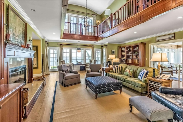 279 Little Neck Rd, Centerport, NY 11721 - living area featuring crown molding, a towering ceiling, hardwood / wood-style flooring, a high end fireplace, and a notable chandelier
