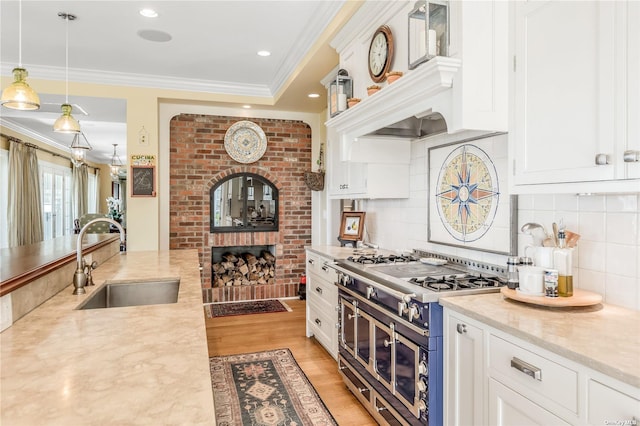 279 Little Neck Rd, Centerport, NY 11721 - kitchen with a sink, double oven range, white cabinets, light wood-style floors, and ornamental molding