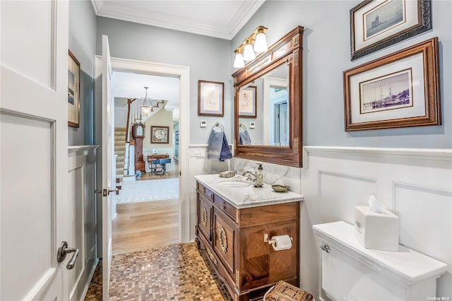 279 Little Neck Rd, Centerport, NY 11721 - bathroom with vanity, wood finished floors, wainscoting, ornamental molding, and an inviting chandelier