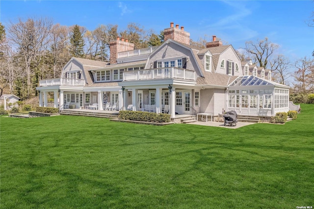 279 Little Neck Rd, Centerport, NY 11721 - back of house with a balcony, a gambrel roof, and a chimney