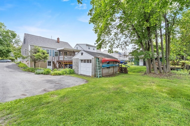 7 Wilson Blvd, Poughkeepsie, NY 12603 - rear view of property featuring driveway, a chimney, a yard, a garage, and an outbuilding