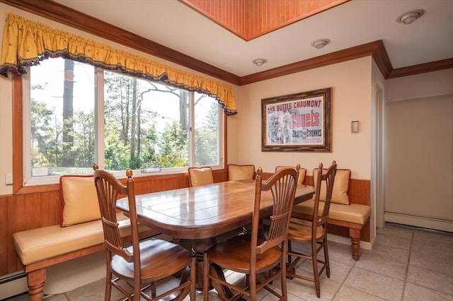56 Milburn Ln, East Hills, NY 11577 - dining space with wooden walls, a wainscoted wall, crown molding, a baseboard radiator, and light tile patterned floors