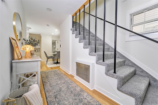 staircase featuring baseboards, recessed lighting, wood finished floors, and visible vents
