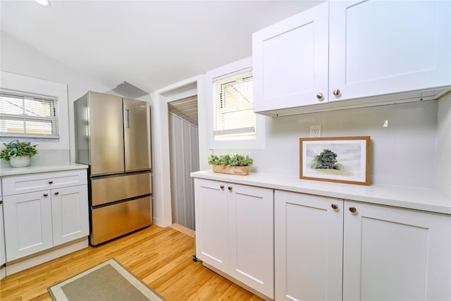 kitchen with light wood-type flooring, freestanding refrigerator, and light countertops