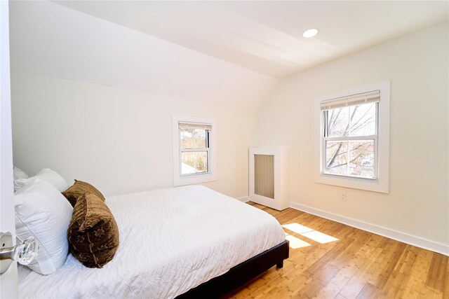 bedroom with light wood-style floors, baseboards, vaulted ceiling, and recessed lighting