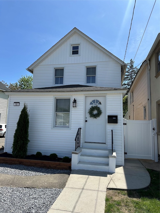 view of front of property featuring entry steps, fence, board and batten siding, and roof with shingles