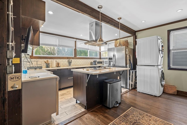 108 Wayne Ave, White Plains, NY 10606 - kitchen with decorative backsplash, light countertops, ventilation hood, stacked washing maching and dryer, and stainless steel refrigerator with ice dispenser