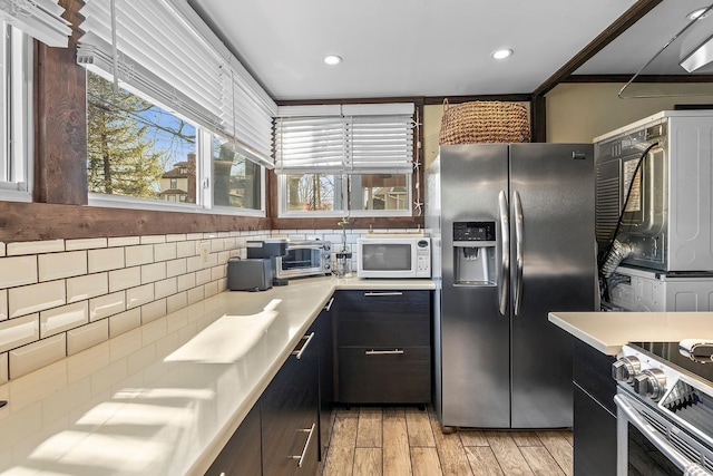 108 Wayne Ave, White Plains, NY 10606 - kitchen featuring light wood-style flooring, stainless steel appliances, light countertops, recessed lighting, and backsplash