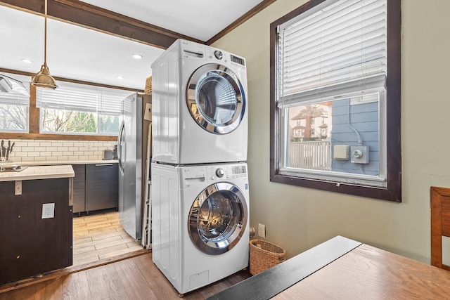 108 Wayne Ave, White Plains, NY 10606 - clothes washing area with light wood finished floors, recessed lighting, stacked washing maching and dryer, laundry area, and crown molding