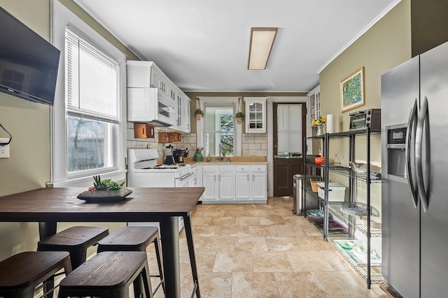 108 Wayne Ave, White Plains, NY 10606 - kitchen with white appliances, decorative backsplash, stone tile flooring, light countertops, and a sink