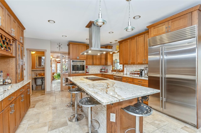 19 Stillwood Rd, Brookhaven, NY 11719 - kitchen featuring appliances with stainless steel finishes, brown cabinets, stone tile flooring, and island exhaust hood