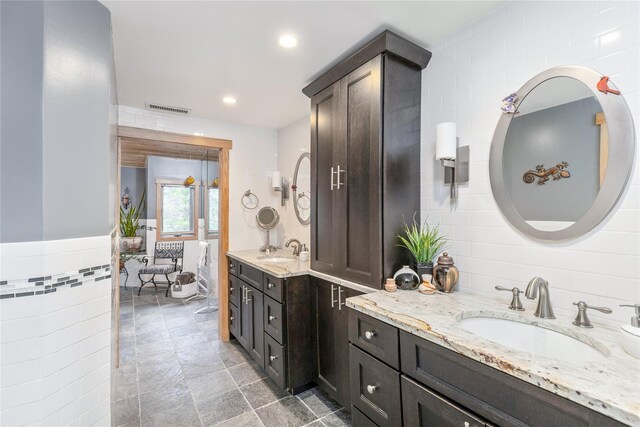 19 Stillwood Rd, Brookhaven, NY 11719 - bathroom featuring tile walls, two vanities, a sink, and visible vents