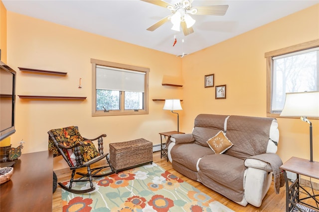 19 Stillwood Rd, Brookhaven, NY 11719 - living area featuring a ceiling fan, a baseboard heating unit, and wood finished floors