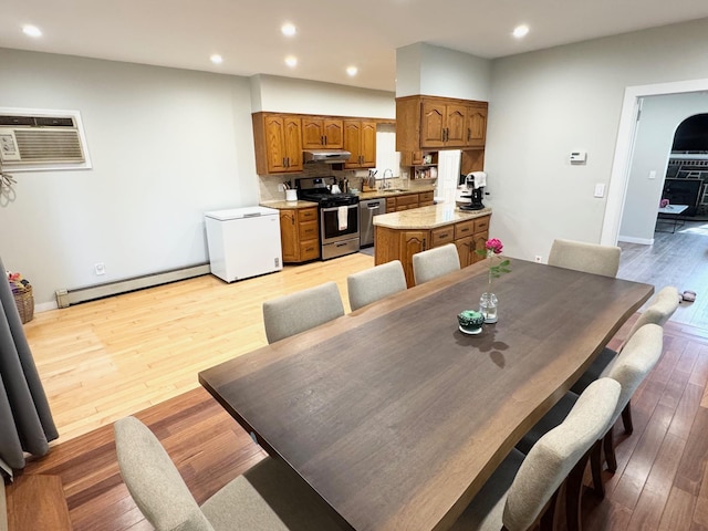 212-04 50th Ave, Bayside, NY 11364 - dining room with baseboard heating, a wall mounted air conditioner, light wood finished floors, recessed lighting, and baseboards