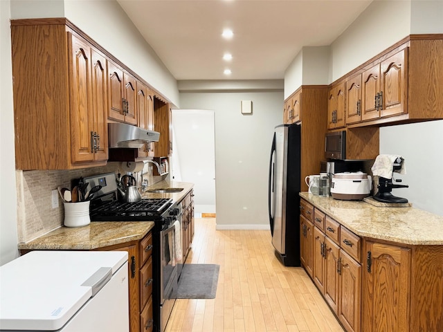 212-04 50th Ave, Bayside, NY 11364 - kitchen featuring stainless steel appliances, under cabinet range hood, a sink, light wood-type flooring, and brown cabinetry
