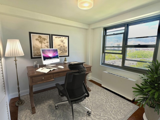 61-20 Grand Central Pkwy Unit A1402, Forest Hills, NY 11375 - home office featuring baseboards, radiator heating unit, and wood finished floors