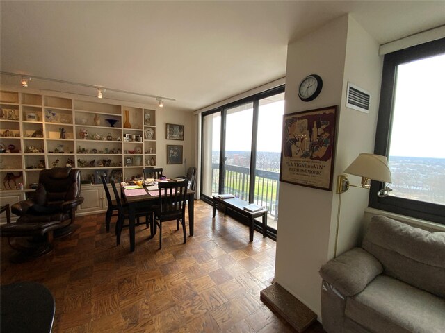 dining room with rail lighting, expansive windows, and visible vents