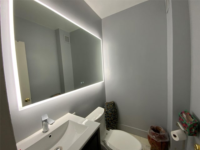 half bathroom featuring toilet, vanity, and visible vents