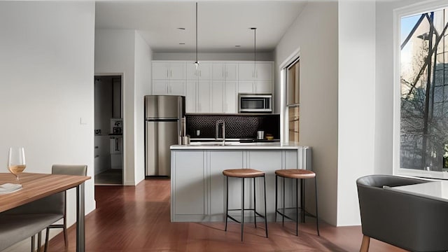 kitchen featuring white cabinets, tasteful backsplash, stainless steel appliances, and light countertops