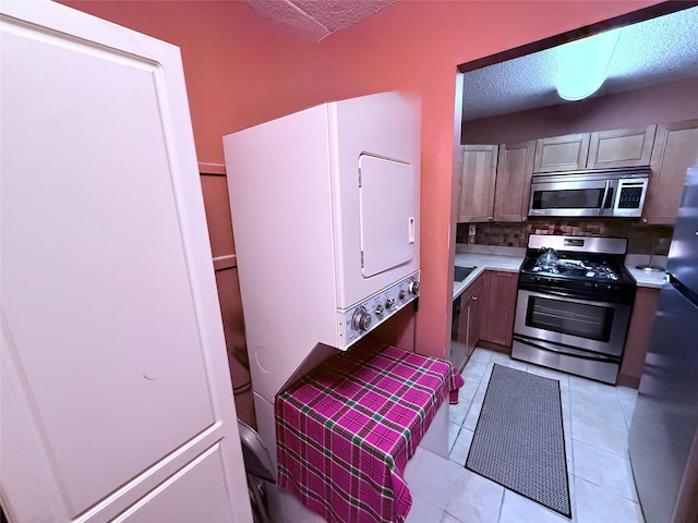 20921 26th Ave Unit 1G, Bayside, NY 11360 - kitchen with tasteful backsplash, light tile patterned floors, light countertops, a textured ceiling, and appliances with stainless steel finishes