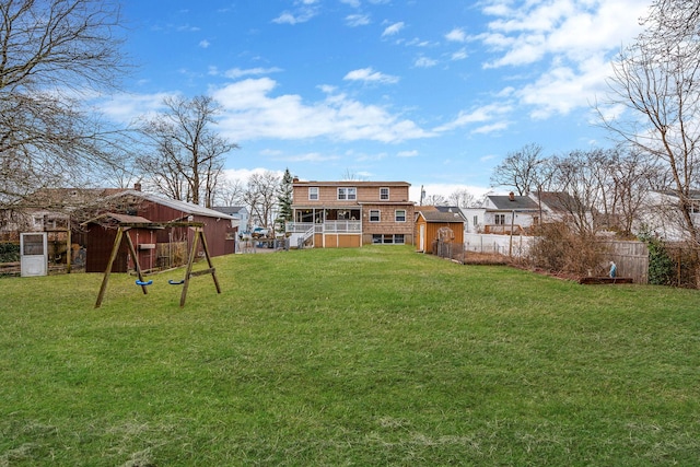 view of yard with a storage unit, fence, and an outbuilding