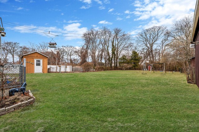 view of yard featuring fence, an outbuilding, and a shed