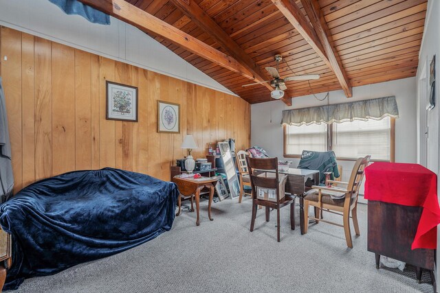 carpeted dining room featuring vaulted ceiling with beams, wood walls, wood ceiling, and ceiling fan