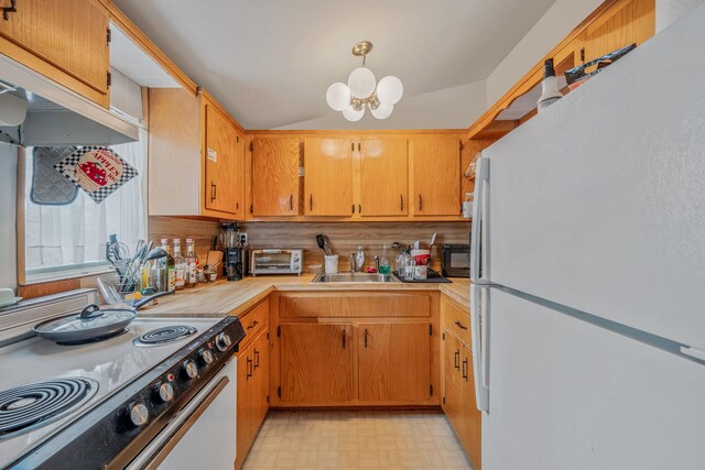 kitchen with tasteful backsplash, light countertops, a sink, an inviting chandelier, and white appliances