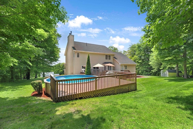 34 Melissa Ln, Washingtonville, NY 10992 - back of house with a storage unit, a chimney, a lawn, and a deck