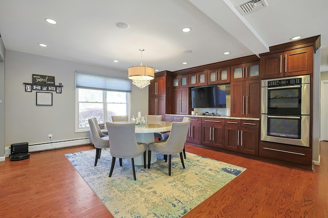 dining space featuring visible vents, wood finished floors, recessed lighting, and a baseboard radiator