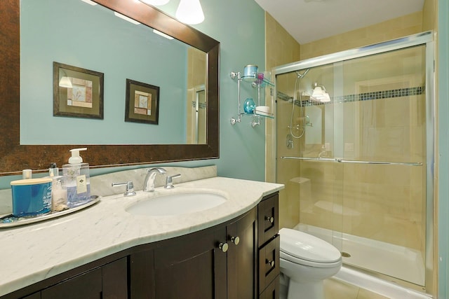 bathroom featuring toilet, a stall shower, and vanity