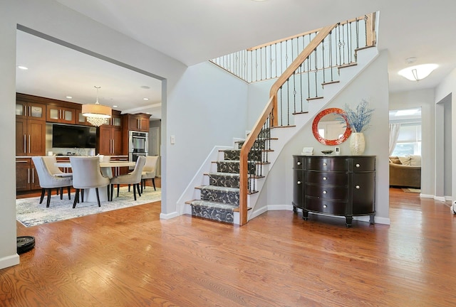 staircase featuring baseboards and wood finished floors
