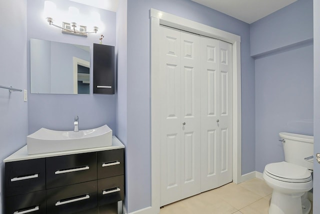 bathroom featuring tile patterned floors, toilet, a closet, and vanity