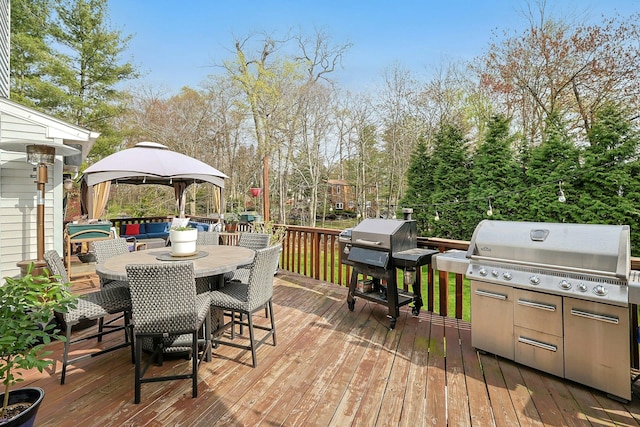 deck with a grill, a gazebo, and outdoor dining area