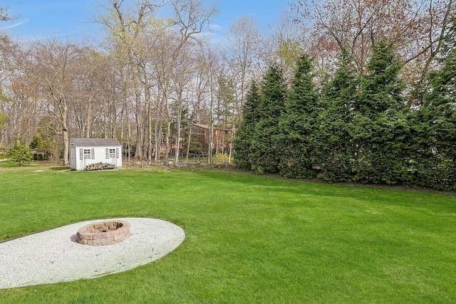 view of yard with a fire pit, an outdoor structure, and a shed