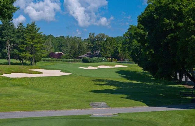 view of property's community featuring a lawn and view of golf course