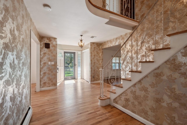 4 Penn Ct, Dix Hills, NY 11746 - foyer entrance with wood finished floors, stairway, an inviting chandelier, baseboards, and wallpapered walls