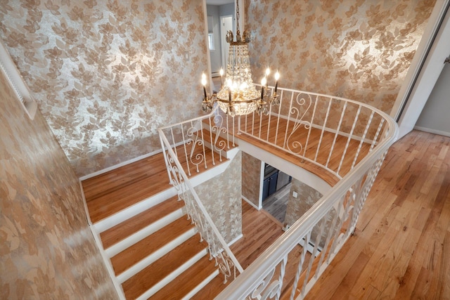 4 Penn Ct, Dix Hills, NY 11746 - stairs featuring baseboards, a notable chandelier, wallpapered walls, and wood finished floors