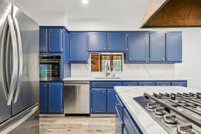 4 Penn Ct, Dix Hills, NY 11746 - kitchen with appliances with stainless steel finishes, blue cabinetry, a sink, light wood-style floors, and recessed lighting