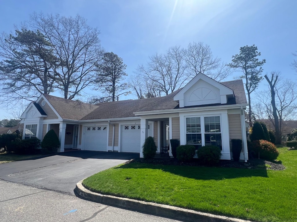 5 Wainscott Ct, Ridge, NY 11961 - view of front facade with driveway, a shingled roof, a garage, and a front lawn