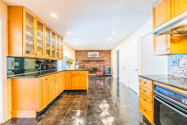 1170 Carlls Straight Path, Dix Hills, NY 11746 - kitchen featuring a brick fireplace, dark countertops, under cabinet range hood, glass insert cabinets, and black appliances