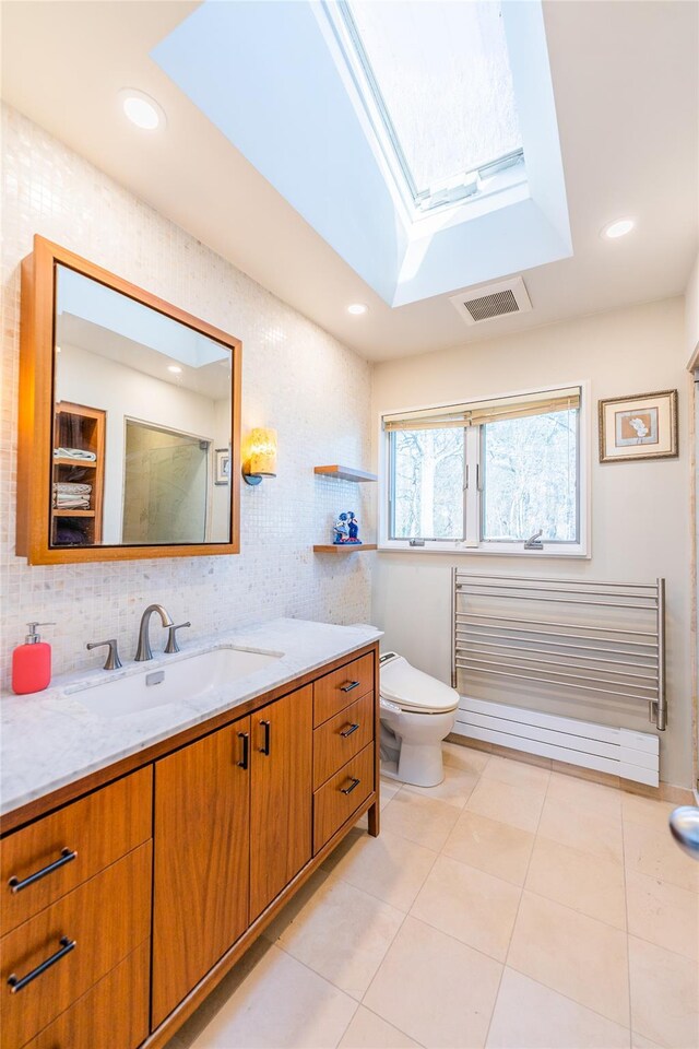 1170 Carlls Straight Path, Dix Hills, NY 11746 - bathroom with tile patterned floors, vanity, tasteful backsplash, and a skylight